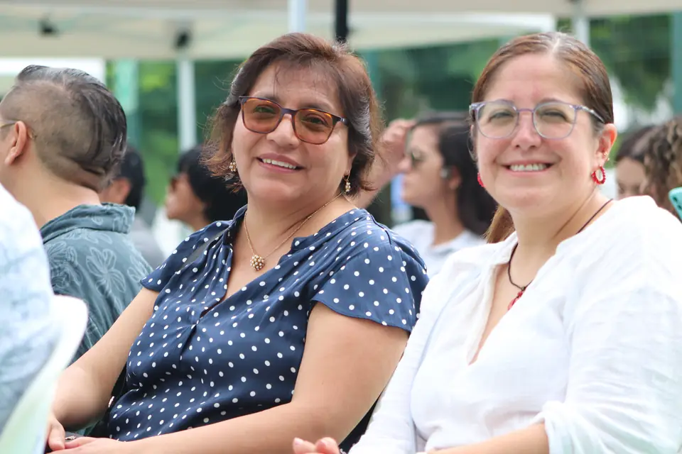 Asistentes sonrientes durante la ceremonia. A la derecha, la Dra. Carolina Montero Calderón, Directora de Investigación de la UCE